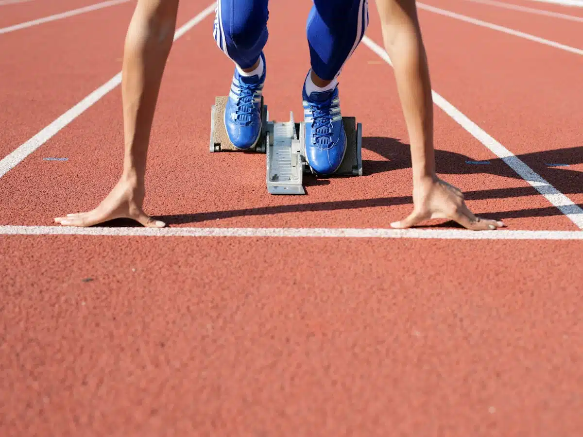 the hands and feet of a runner on the blocks ready to start a race