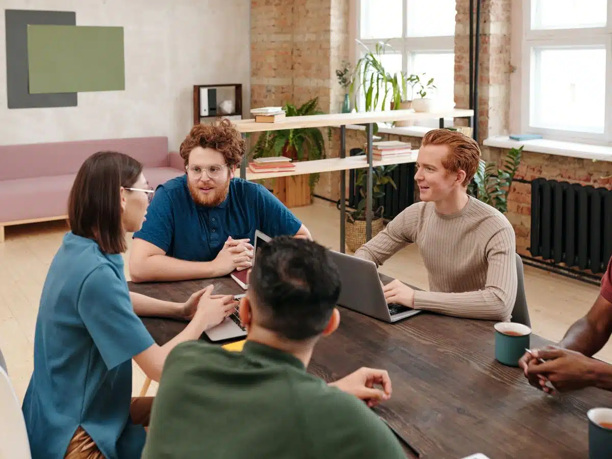 a group of professionals sit around a table at a brainstorming meeting