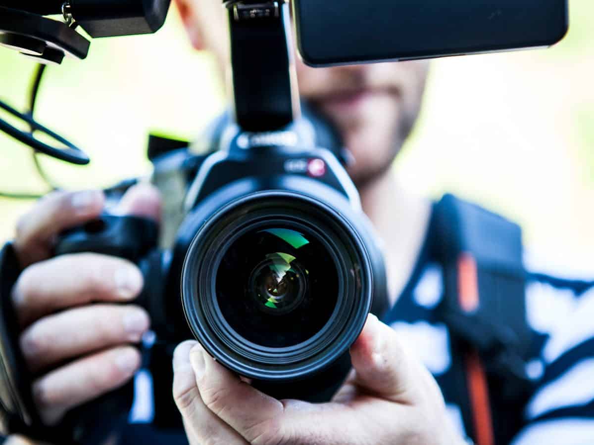 camera with the lens close to the viewer, held by a man