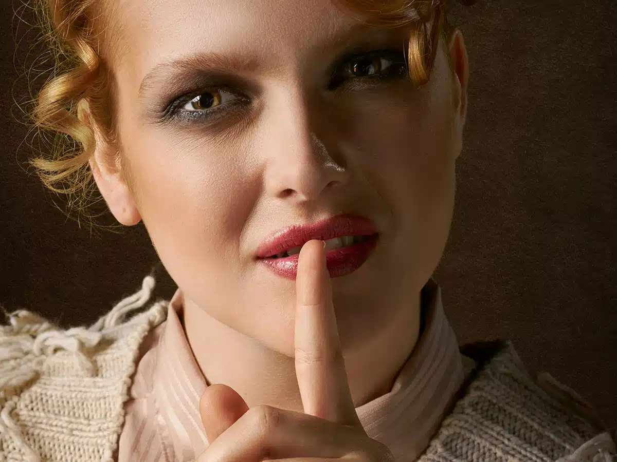 Woman with an index finger to her lips