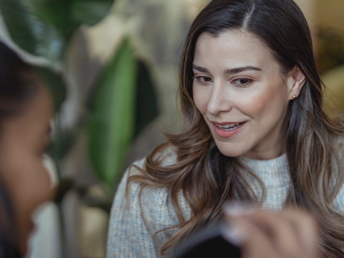 White woman listening to a customer story told by a black woman