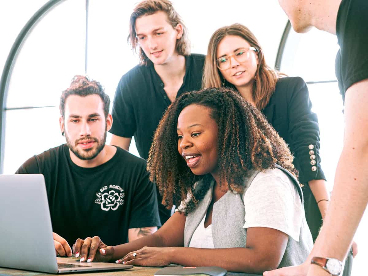 four people watching an employee onboarding video on a laptop